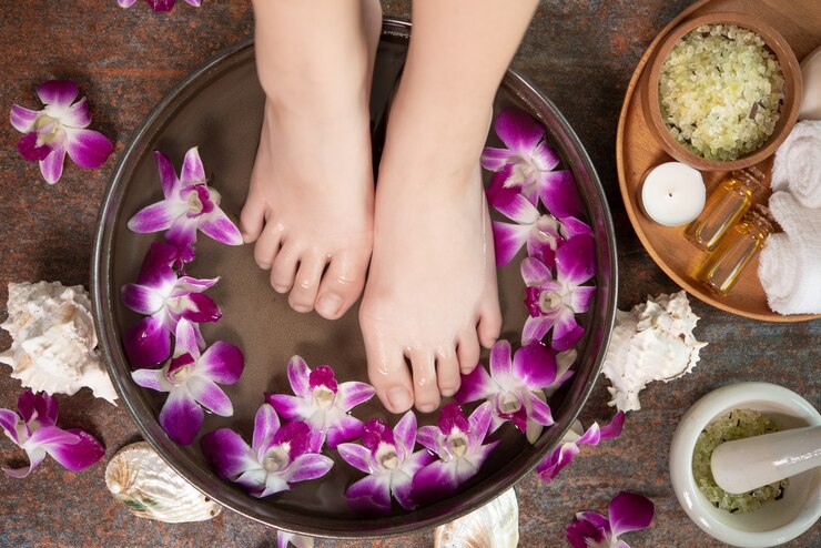 A serene image of a woman's feet adorned with flowers next to a bowl of water, emphasizing Lashika footcare advice.